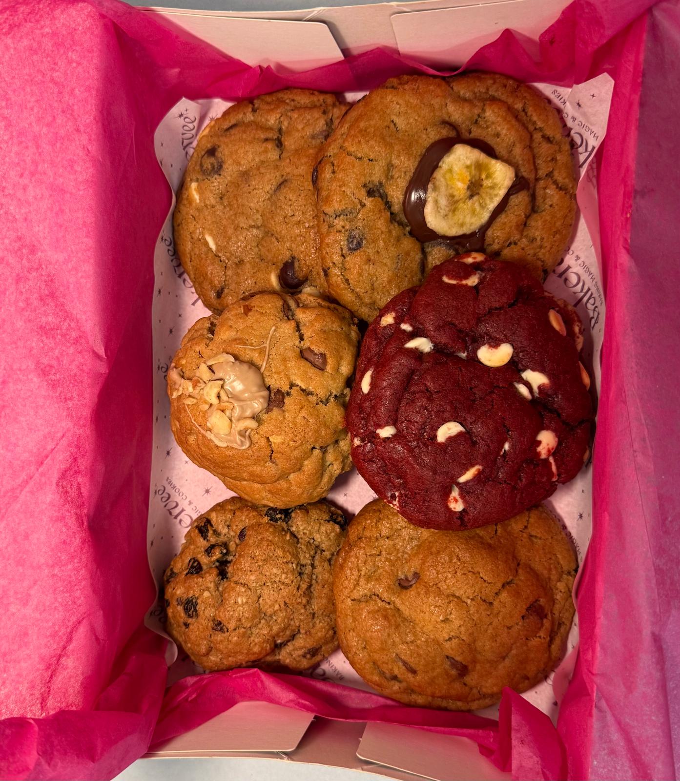 An open Bakervee gift box of six freshly baked premium cookies on branded tissue paper